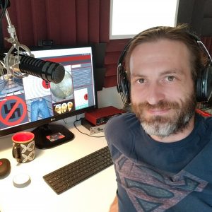 The same photo of Dirk Primbs at the podcasting desk, cropped square.